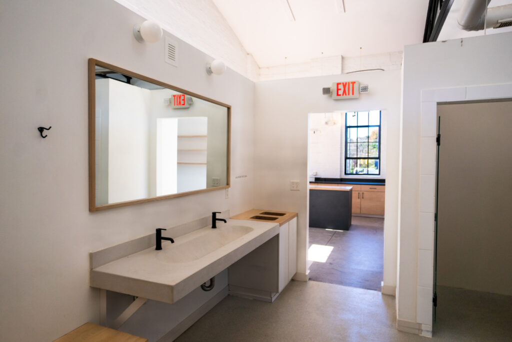 Vanity area at the Bathhouse with a long sink and mirror